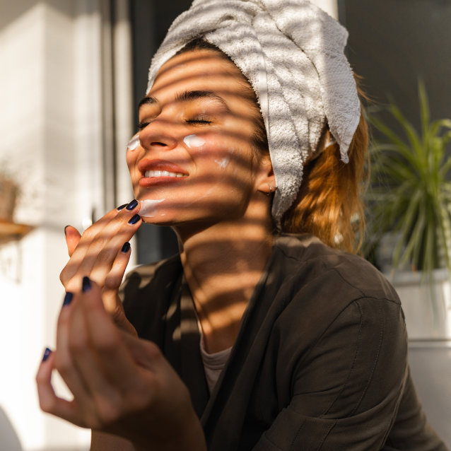 Woman applying skincare products on her face