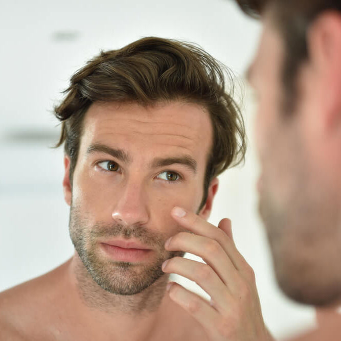 man applying anti-aging cream for glowing skin